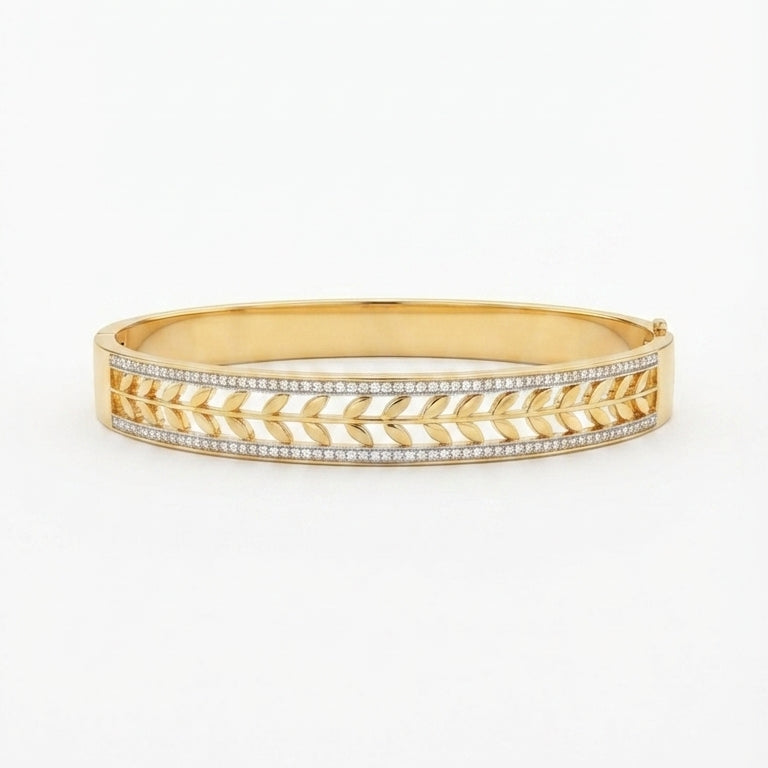 A gold bangle bracelet featuring a textured chevron pattern with pavé-set clear stones on the front, shown against a plain white background.