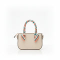 A structured cream-colored leather handbag with a floral-patterned scarf tied to its top handles, set against a plain white background.
