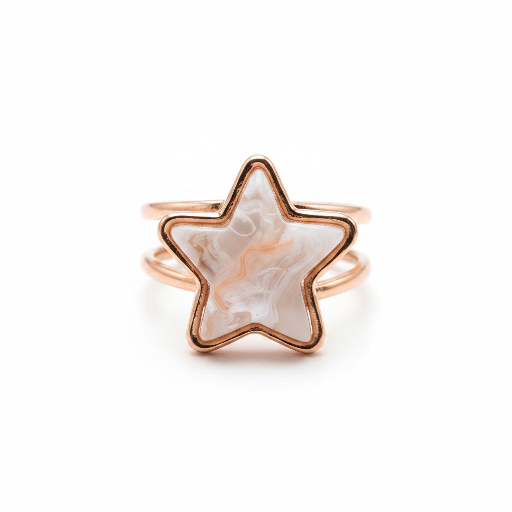 A rose gold star-shaped ring featuring a white and peach agate inlay, set against a clean white background.