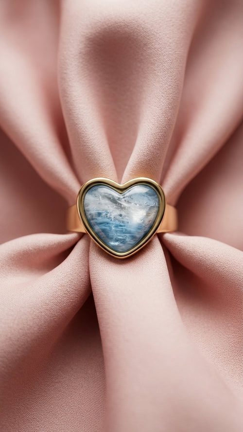 A heart-shaped gold ring with a blue marbled gemstone, shown from multiple angles on a clean white background.