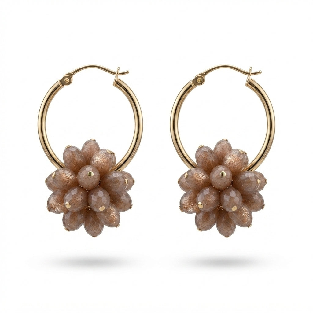 A pair of gold hoop earrings with dangling flower-shaped charms made of faceted taupe beads, shown on a clean white background.