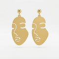 A 2x2 collage showing a pair of gold-tone statement earrings with a minimalist face cutout design. The top-left panel shows the earrings hanging against a white background, and the top-right panel shows them from the back with butterfly backings.