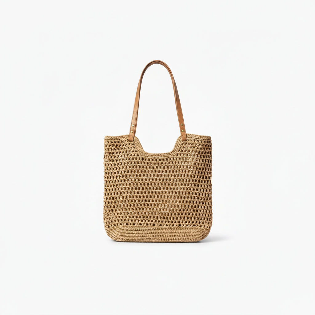 A natural woven straw tote bag with tan leather shoulder straps, shown against a plain white background.